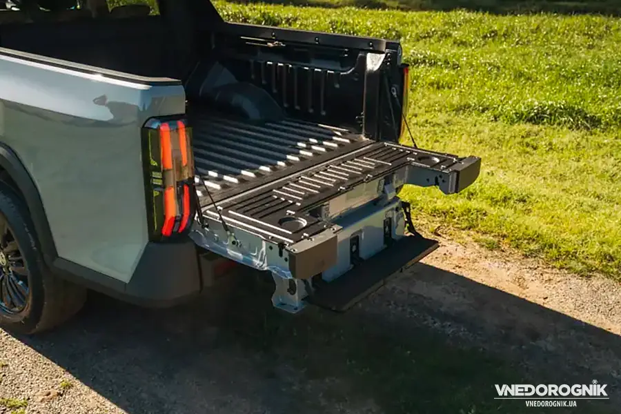 Вигляд ззаду на пікап MG U9 з відкритим бортом та інтегрованою сходинкою для легкого доступу в кузов. Задній борт та кузов пікапа MG U9.