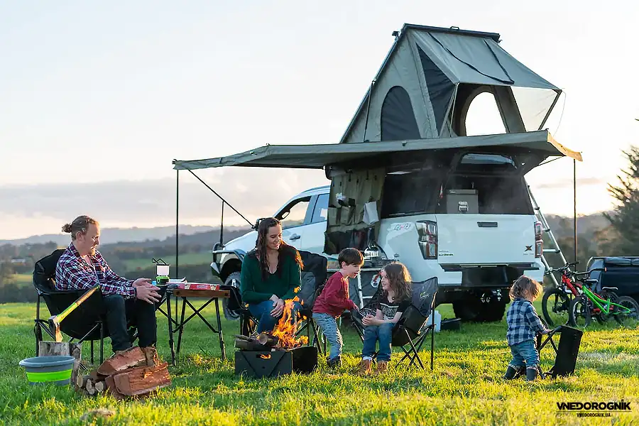 Родина насолоджується вечором у кемпінгу після експедиційного дня. Саме такі моменти роблять подорожі пікапом справжніми та незабутніми.