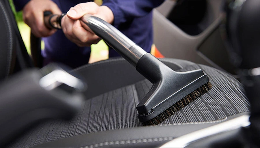 Cleaning an off-road SUV interior with a car vacuum after an off-road drive